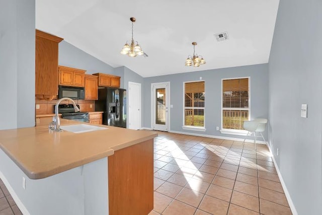 kitchen featuring light tile patterned floors, an inviting chandelier, lofted ceiling, and black appliances