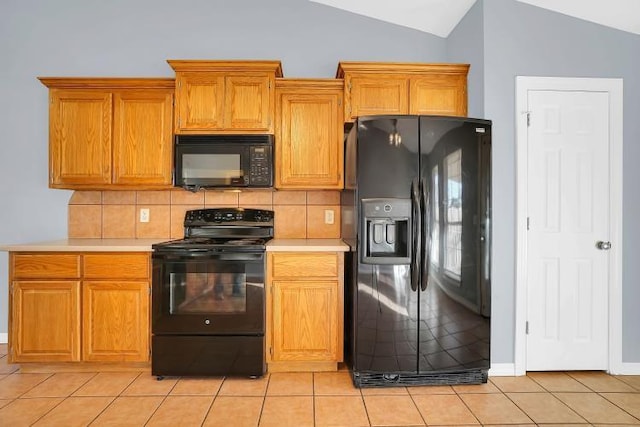 kitchen featuring tasteful backsplash, light tile patterned floors, black appliances, and lofted ceiling