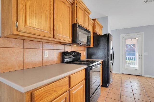 kitchen with black appliances, light tile patterned floors, and tasteful backsplash