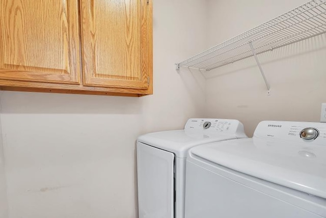 laundry room with cabinets and washer and clothes dryer