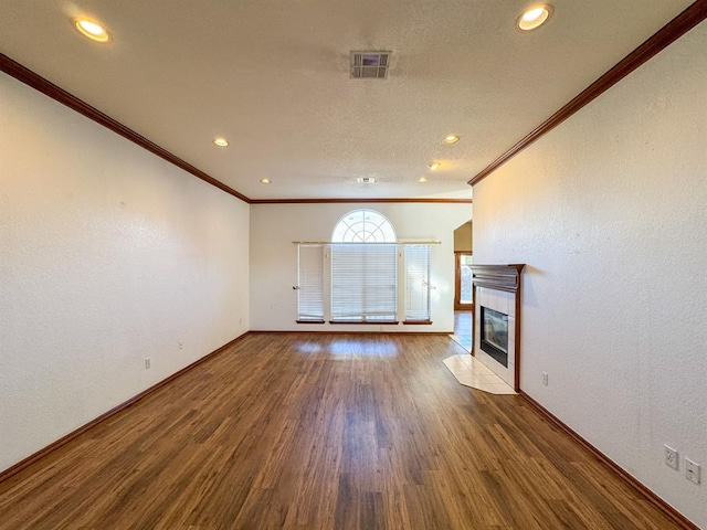 unfurnished living room featuring hardwood / wood-style flooring, ornamental molding, and a tile fireplace