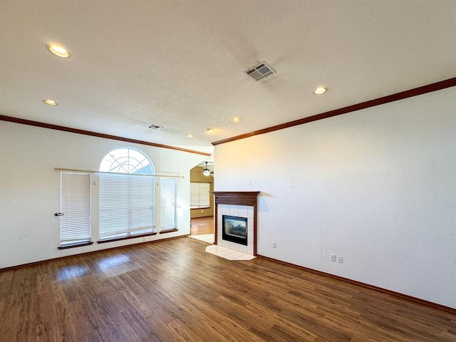 unfurnished living room featuring a tile fireplace, hardwood / wood-style floors, and crown molding