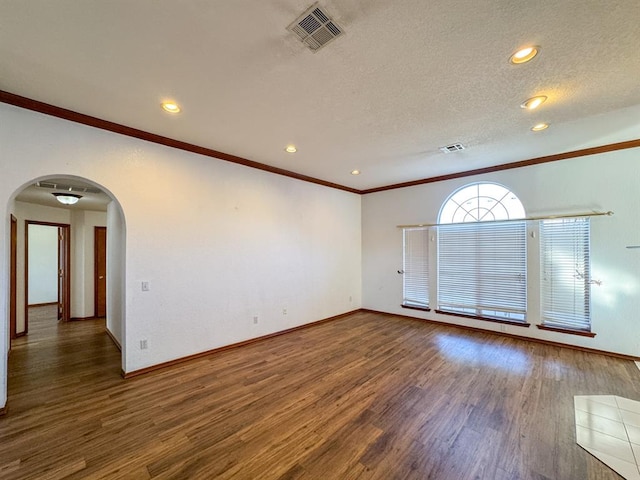 unfurnished room featuring a textured ceiling, ornamental molding, and dark wood-type flooring