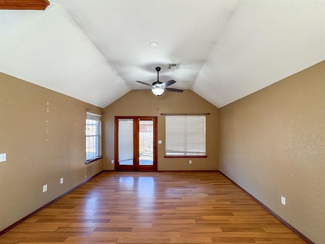 unfurnished room featuring ceiling fan, light wood-type flooring, and vaulted ceiling