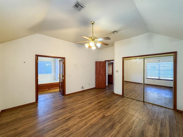 unfurnished bedroom with ceiling fan, dark wood-type flooring, and lofted ceiling