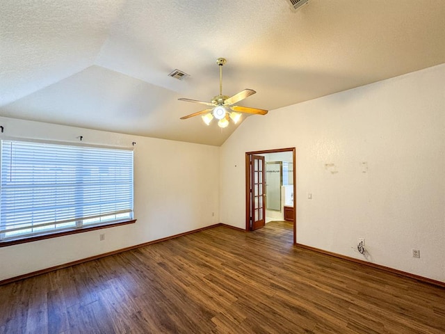 empty room featuring ceiling fan, dark hardwood / wood-style flooring, a textured ceiling, and vaulted ceiling