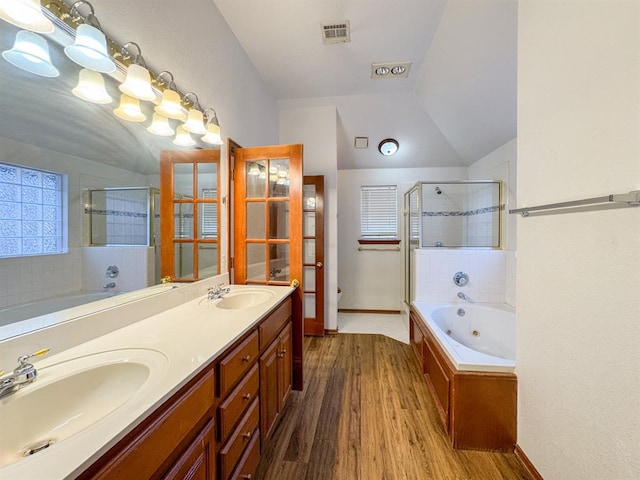 bathroom featuring independent shower and bath, vanity, wood-type flooring, and lofted ceiling