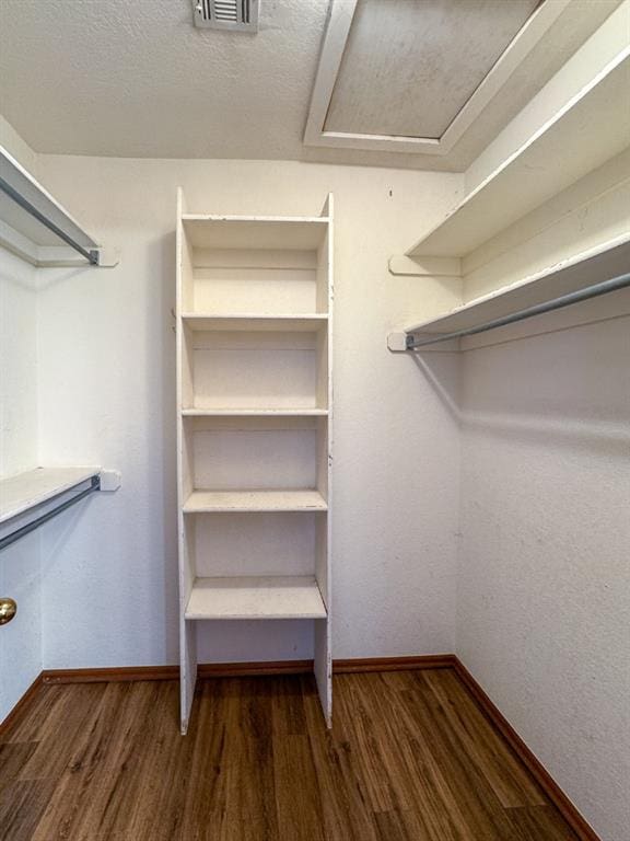 walk in closet with dark hardwood / wood-style floors