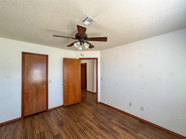 unfurnished bedroom with ceiling fan, dark hardwood / wood-style flooring, and a textured ceiling