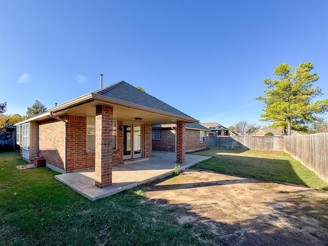 rear view of property featuring a patio area and a lawn