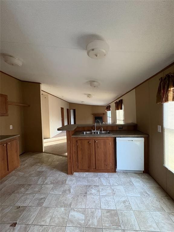 kitchen with a textured ceiling, dishwasher, kitchen peninsula, and sink