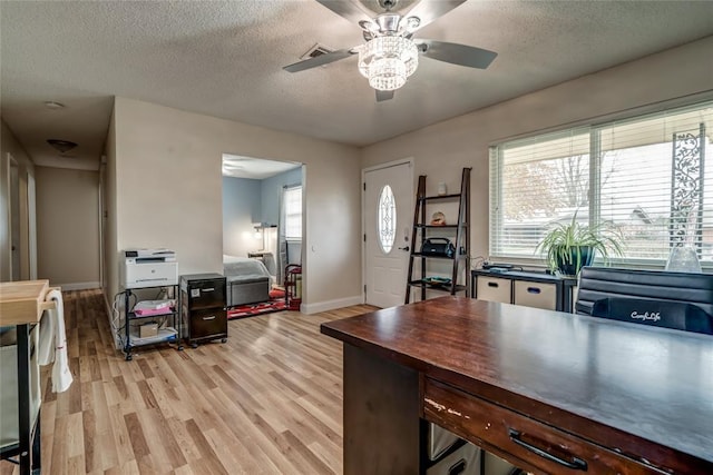 office with ceiling fan, light hardwood / wood-style floors, and a textured ceiling