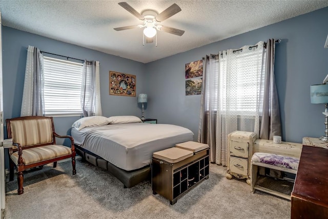 bedroom featuring ceiling fan, carpet, a textured ceiling, and multiple windows