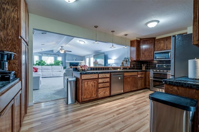 kitchen featuring vaulted ceiling with beams, decorative backsplash, hanging light fixtures, light wood-type flooring, and stainless steel appliances