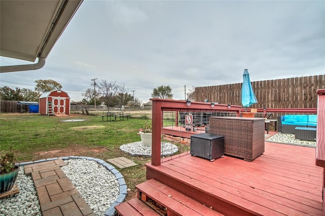 deck with a storage shed, an outdoor living space, and a lawn