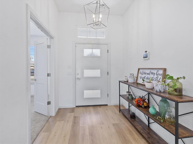 foyer featuring light wood-type flooring and a chandelier