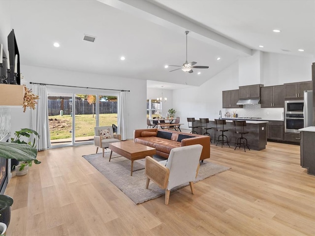 living room with beam ceiling, high vaulted ceiling, ceiling fan with notable chandelier, and light wood-type flooring