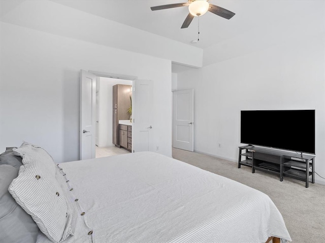 bedroom featuring ensuite bath, light carpet, and ceiling fan