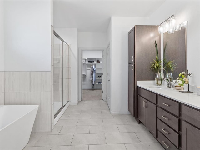 bathroom featuring tile patterned flooring, vanity, and shower with separate bathtub