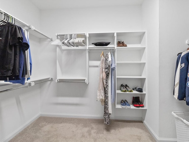 walk in closet featuring light carpet