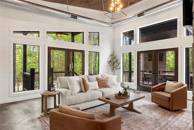 sunroom / solarium featuring an inviting chandelier, lofted ceiling, wood ceiling, and french doors