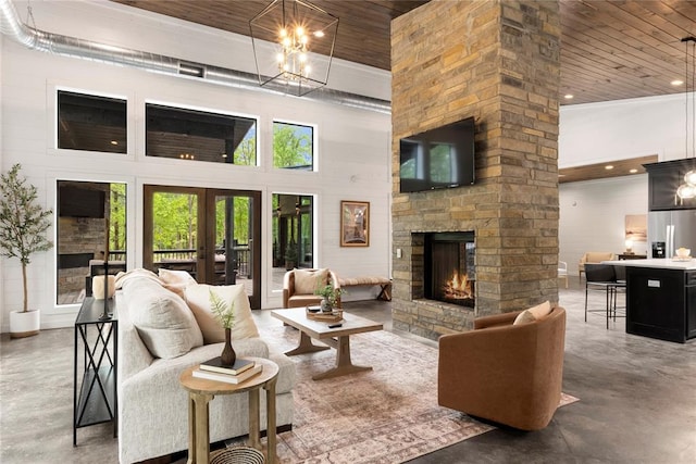 living room with wooden ceiling, french doors, a towering ceiling, a fireplace, and concrete floors