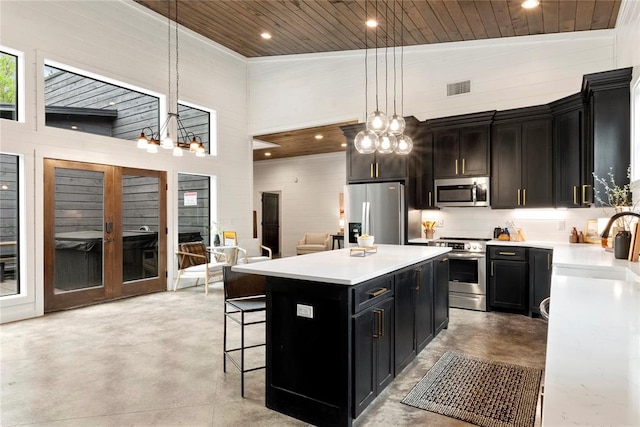 kitchen featuring a center island, high vaulted ceiling, pendant lighting, and appliances with stainless steel finishes