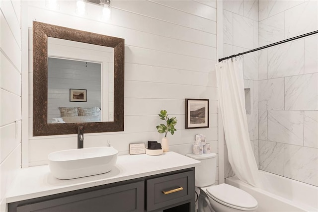 full bathroom featuring wooden walls, vanity, shower / bath combination with curtain, and toilet