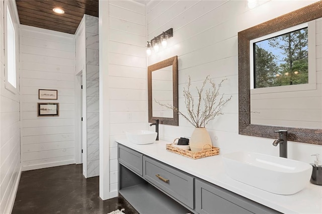 bathroom with vanity, wood walls, and concrete floors