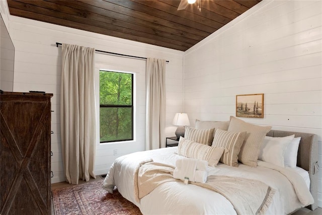 bedroom featuring wooden walls, hardwood / wood-style floors, wooden ceiling, and lofted ceiling