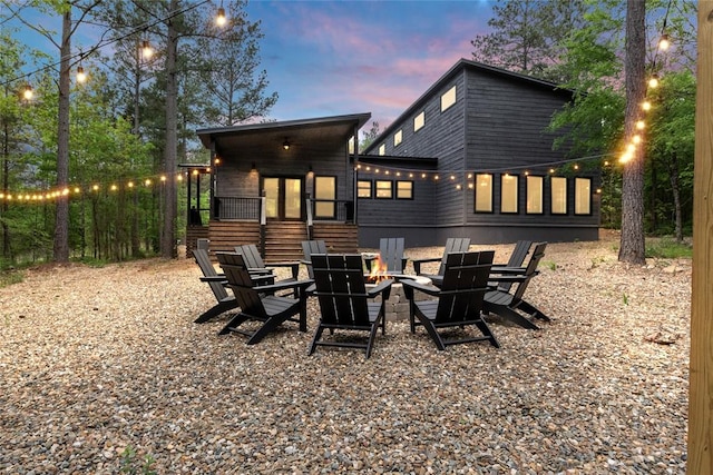 back house at dusk featuring an outdoor fire pit