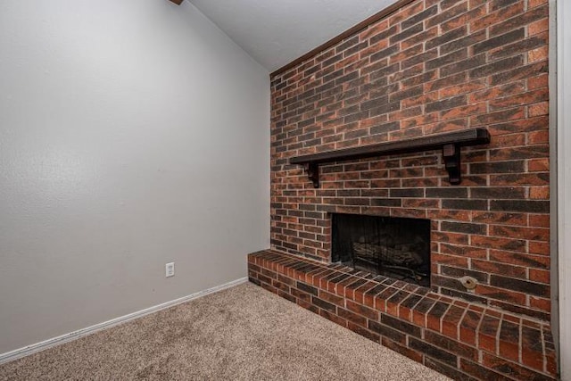 unfurnished living room with carpet, vaulted ceiling, and a brick fireplace