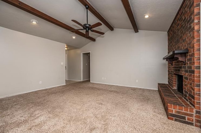 unfurnished living room with carpet flooring, lofted ceiling with beams, a brick fireplace, and ceiling fan