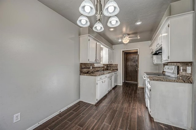 kitchen with dark stone counters, dark wood-type flooring, pendant lighting, white range with electric cooktop, and white cabinetry