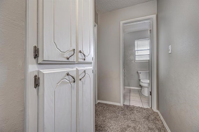 bathroom featuring tile patterned floors, a textured ceiling, and toilet