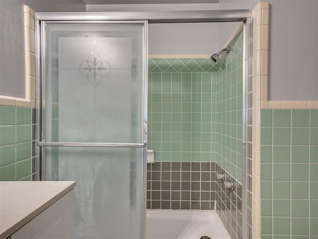 bathroom featuring vanity and tile walls