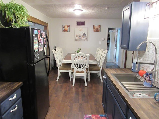 dining space featuring sink, dark hardwood / wood-style floors, and a textured ceiling