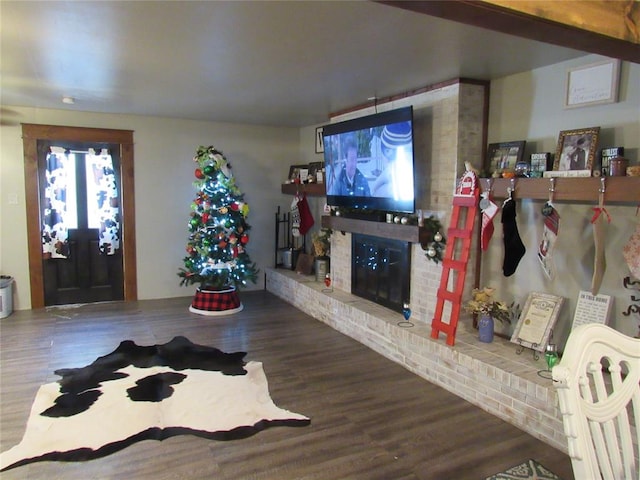 living room with hardwood / wood-style flooring and a brick fireplace