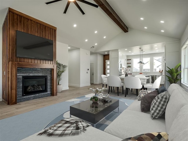 living room with a stone fireplace, high vaulted ceiling, ceiling fan, light hardwood / wood-style floors, and beam ceiling