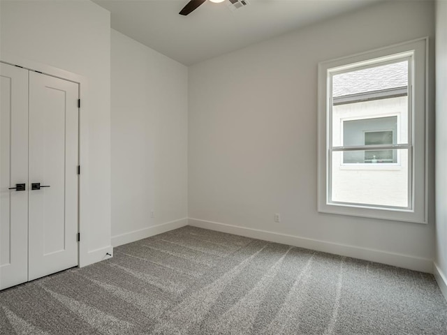 spare room featuring ceiling fan, a healthy amount of sunlight, and carpet