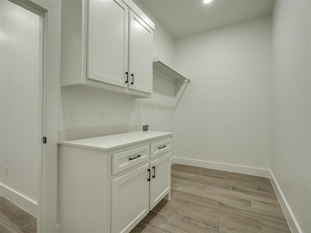 laundry room with cabinets and light wood-type flooring