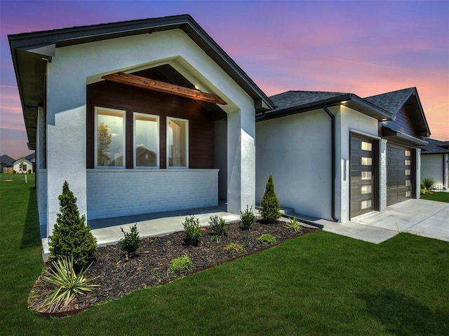 contemporary home featuring a garage and a lawn