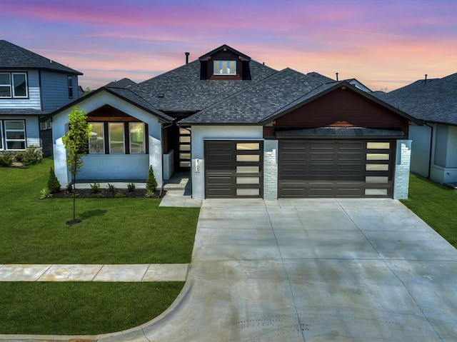 view of front of house with a garage and a lawn