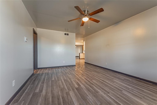 empty room with ceiling fan and dark wood-type flooring