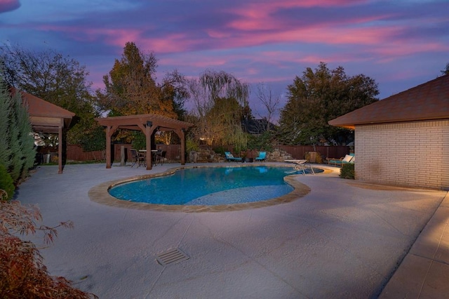 pool at dusk with a patio area and a gazebo