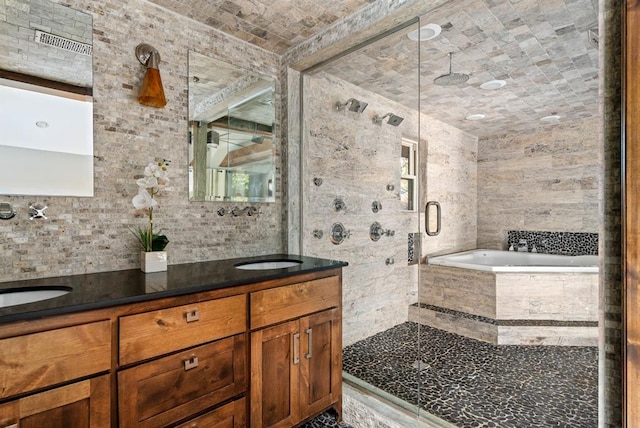 bathroom with vanity, shower with separate bathtub, and tile walls