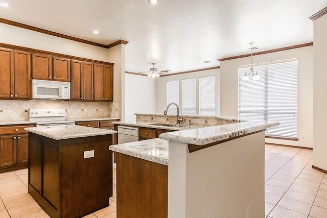 kitchen featuring a center island, sink, decorative light fixtures, white appliances, and ceiling fan with notable chandelier