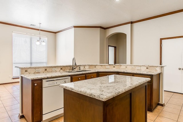 kitchen featuring white dishwasher, sink, hanging light fixtures, light tile patterned floors, and a kitchen island