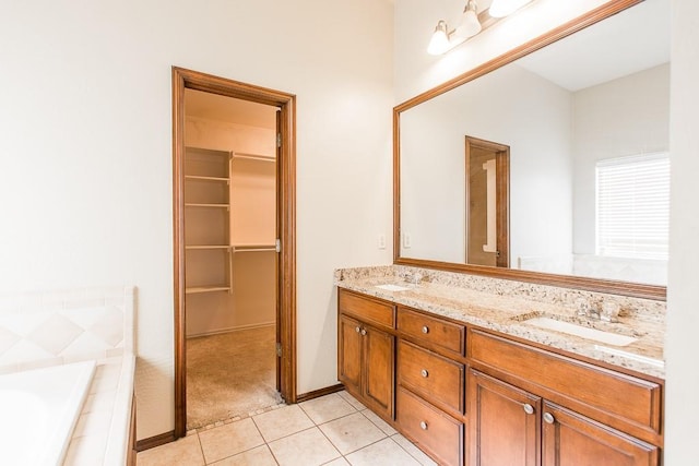 bathroom with tile patterned flooring, a walk in closet, a sink, and double vanity