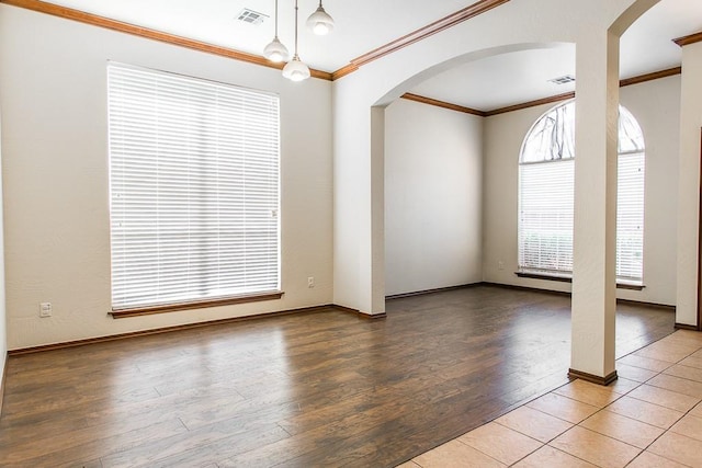 unfurnished room featuring crown molding, visible vents, arched walkways, and wood finished floors